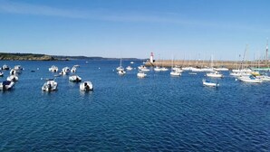 A marina with numerous boats docked and a lighthouse in the background. - Charming townhouse, 10 minutes walk from the beach! (Erquy)