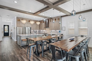 A modern kitchen with a central island, wooden flooring, and pendant lighting. - Ahhhmazing Unmatched amenities+Golf Cart+Chair service+12-person Hot Tub+Rooftop (Destin)