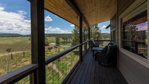 Une terrasse en bois offrant une vue sur un lac et une forêt.