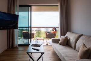 A modern living room with a sofa, a coffee table, and a TV mounted on the wall.