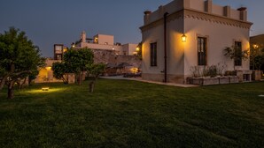 Un edificio con patio, piscina pequeña y mobiliario exterior.