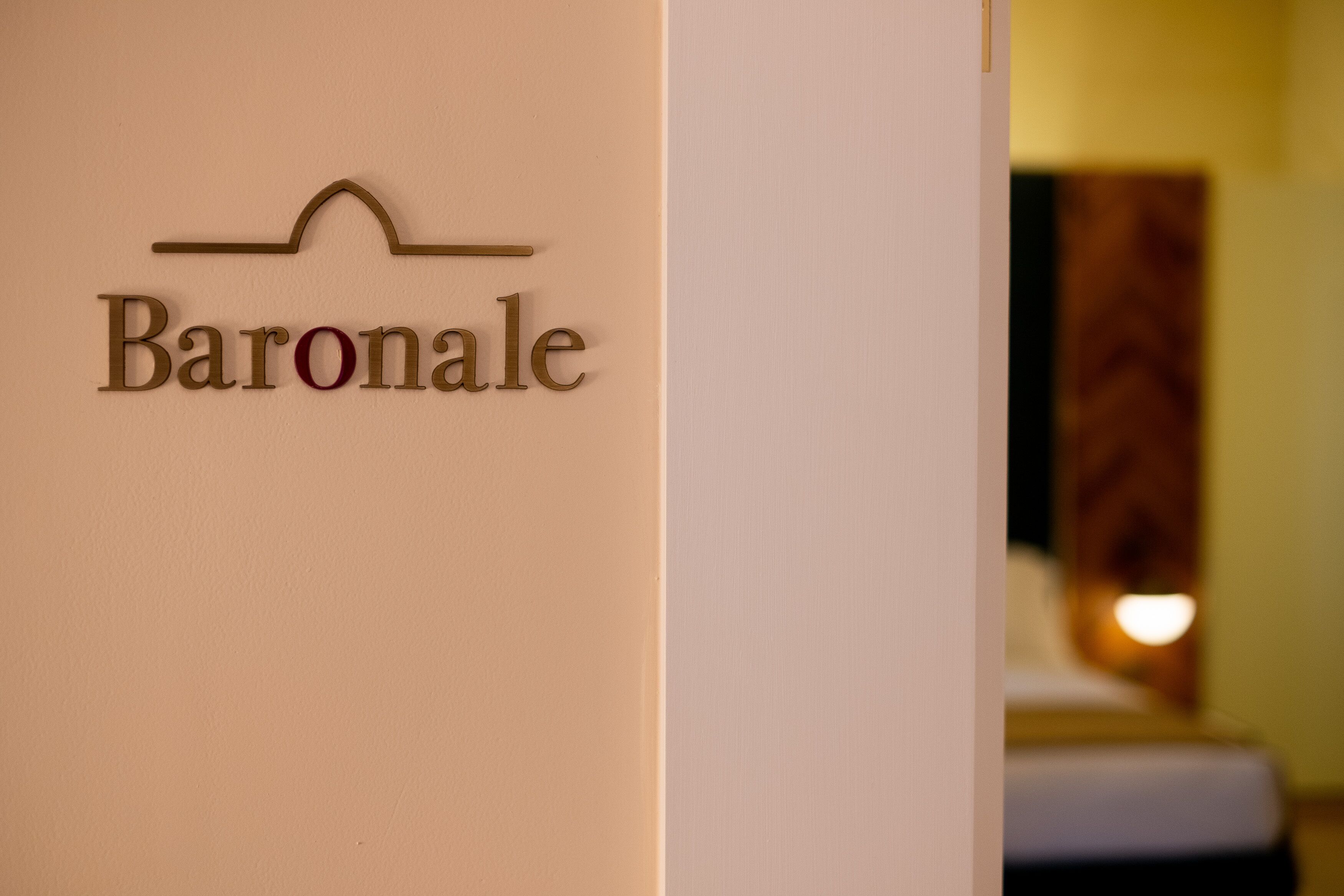 A sign with the word "Baronale" on a beige wall, indicating a hotel or establishment.