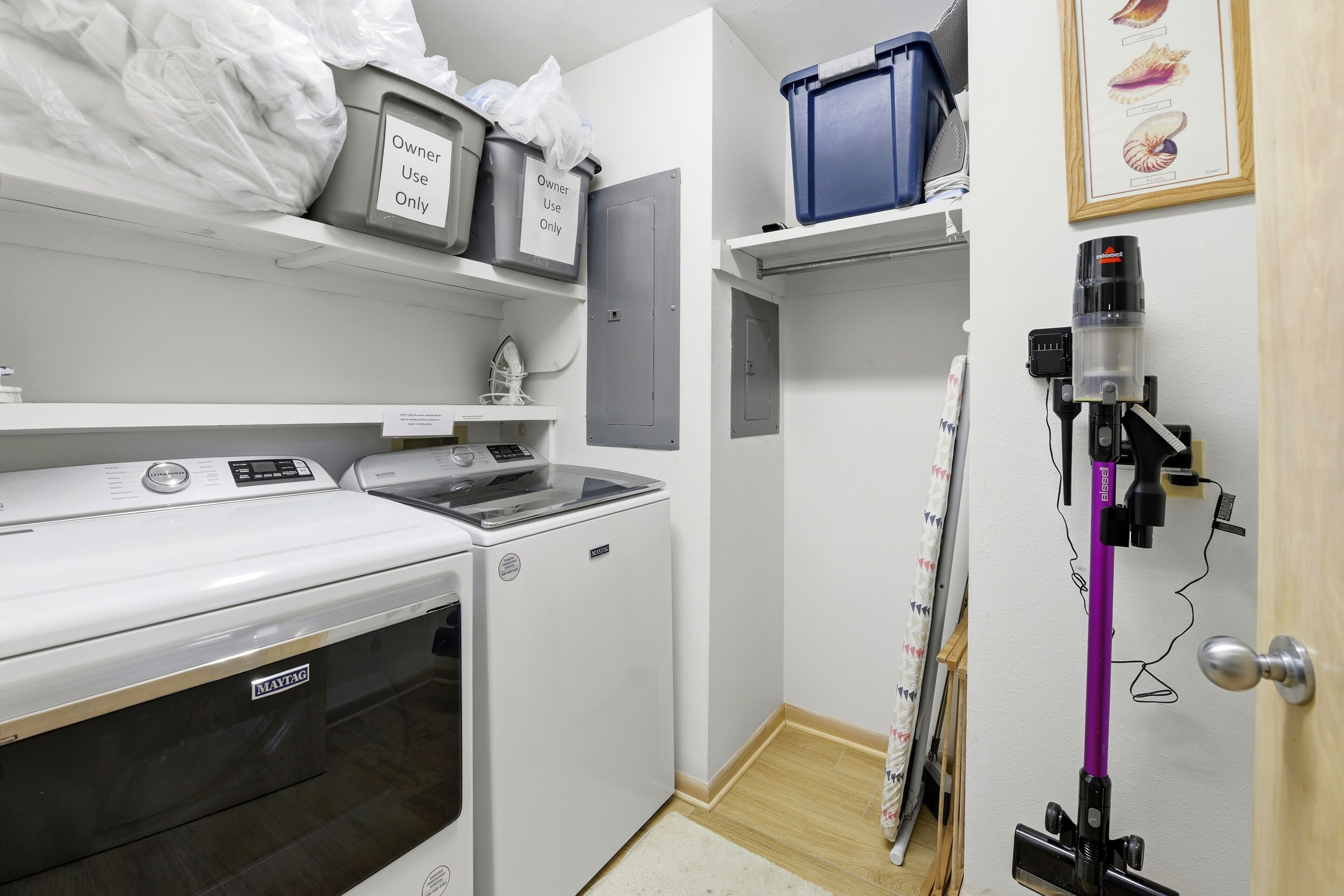 A laundry room with a washing machine, dryer, and a vacuum cleaner.