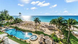 Un resort con piscina, zona de playa y palmeras.
