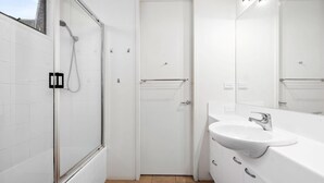 A modern bathroom with a glass shower enclosure, a white sink, and a large mirror. - Spindrift Point Lonsdale (Point Lonsdale)