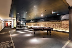 Relax and unwind in our indoor recreational area, featuring a pool table and a well-planned layout.