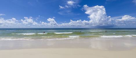 Una playa con cielo despejado y olas.