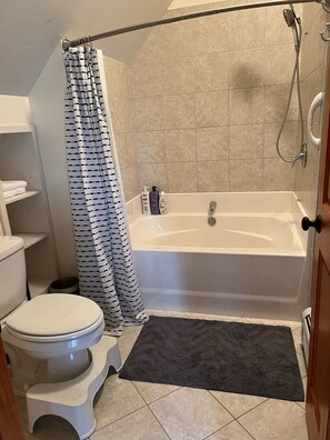 A bathroom with a bathtub, toilet, and shower curtain. - Back Lake Views! Sleeps 12, Flat Rate, Direct ATV & Private Snowmobile Access! (Pittsburg)