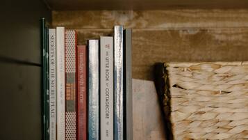 A bookshelf with books and a woven basket.