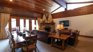 A spacious living area with a stone fireplace, wooden furniture, and a flat-screen TV. - Flagstaff Two Bedroom 2 Apartment Hotel by RedAwning (Park City)