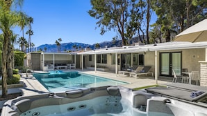 A pool area with hot tubs, lounge chairs, and a view of mountains. - Sunset Ranch - Updated midcentury home with Pool & Spa! (Palm Springs)