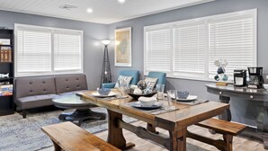 A dining area with a wooden table, benches, and a sofa. - ❤️ Spacious Island Cottage at Indian Lake ❤️ (Huntsville)