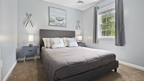 A bedroom with a bed, nightstands, a ceiling fan, a window with curtains, and wall art. - ❤️ Spacious Island Cottage at Indian Lake ❤️ (Huntsville)