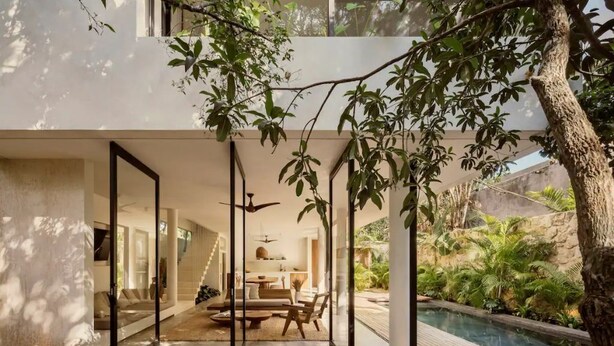A modern house with a wooden deck, a glass-enclosed patio, and a pool. - Casa Areca, 4 bed/4.5 bath World Renowned Design Villa, Pool, Rooftop, 24/7Guard (Tulum)