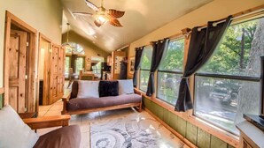 A cozy room with a wooden bench, a sofa, and a ceiling fan. - RR 7465 Lil Kahuna (New Braunfels)