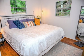 A bedroom with a bed, a bedside table, a lamp, and a window with blinds. - Awesome Views • HOT TUB • Outdoor Shower • Fast Wifi (Murphy)