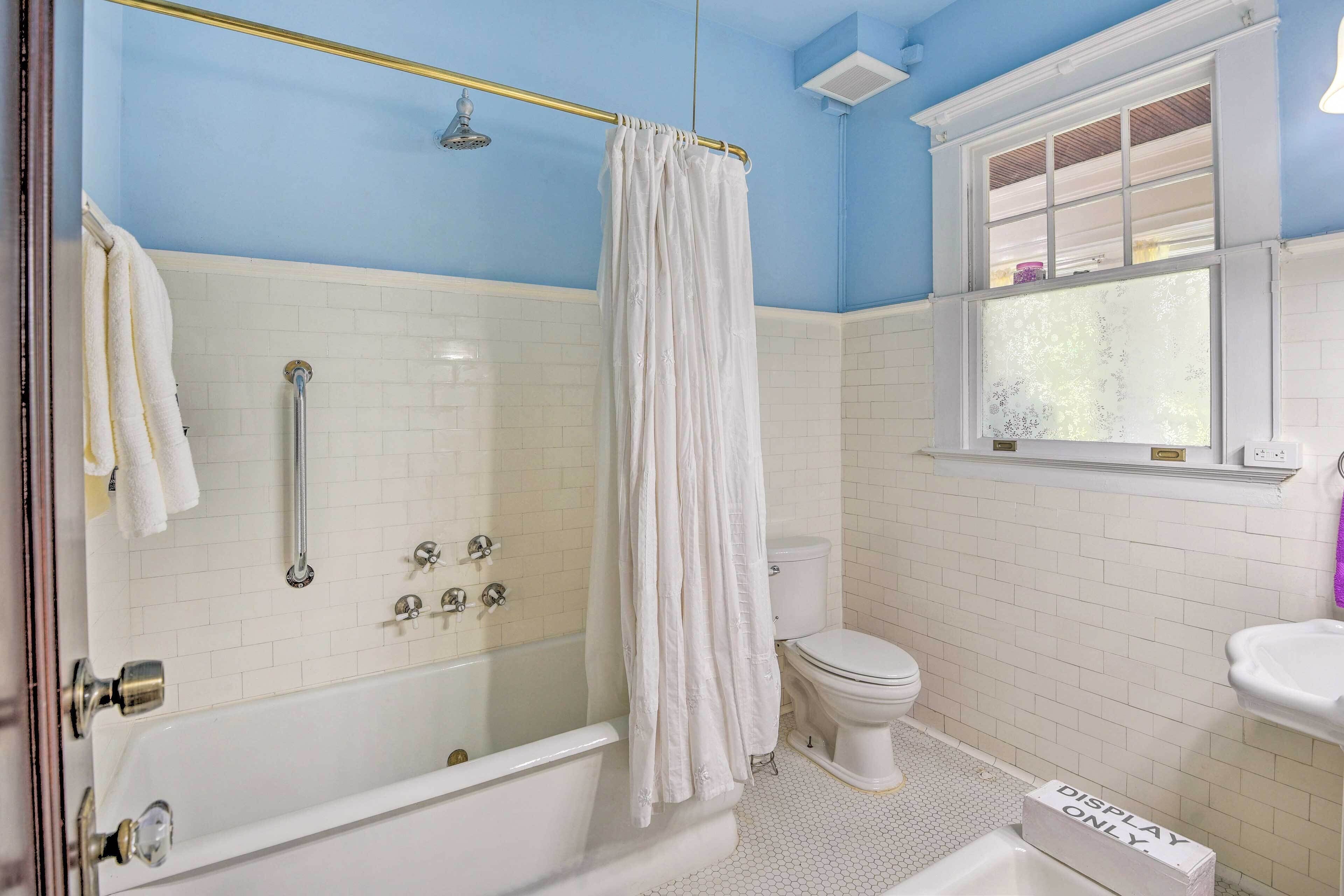 A bathroom with a bathtub, shower, and toilet.