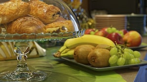 Una mesa de buffet con una cúpula de vidrio que cubre pasteles y una variedad de frutas y verduras.