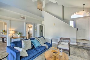 Relax in this inviting living area with a sofa, wicker chair, and coffee table.