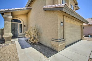 Stucco exterior with a textured finish, prominent garage door, and well-maintained front yard.