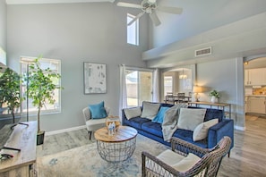 Relax in this spacious living area with a large sofa, coffee table, and wicker chair.