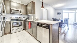 A modern kitchen with stainless steel appliances, wooden cabinets, and a central island.