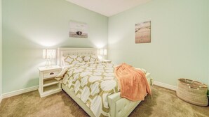 A bedroom with a bed, nightstand, and wall art.