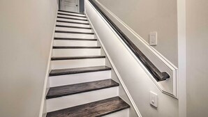 A staircase with white walls and dark wooden steps. - Tasteful Durham Townhome - 6 Mi to Downtown! (Durham)