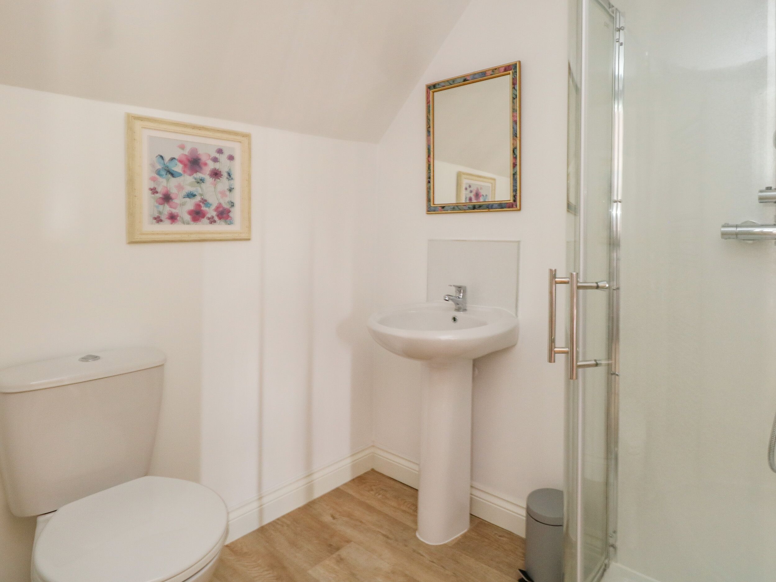 A bathroom with a toilet, sink, and shower.