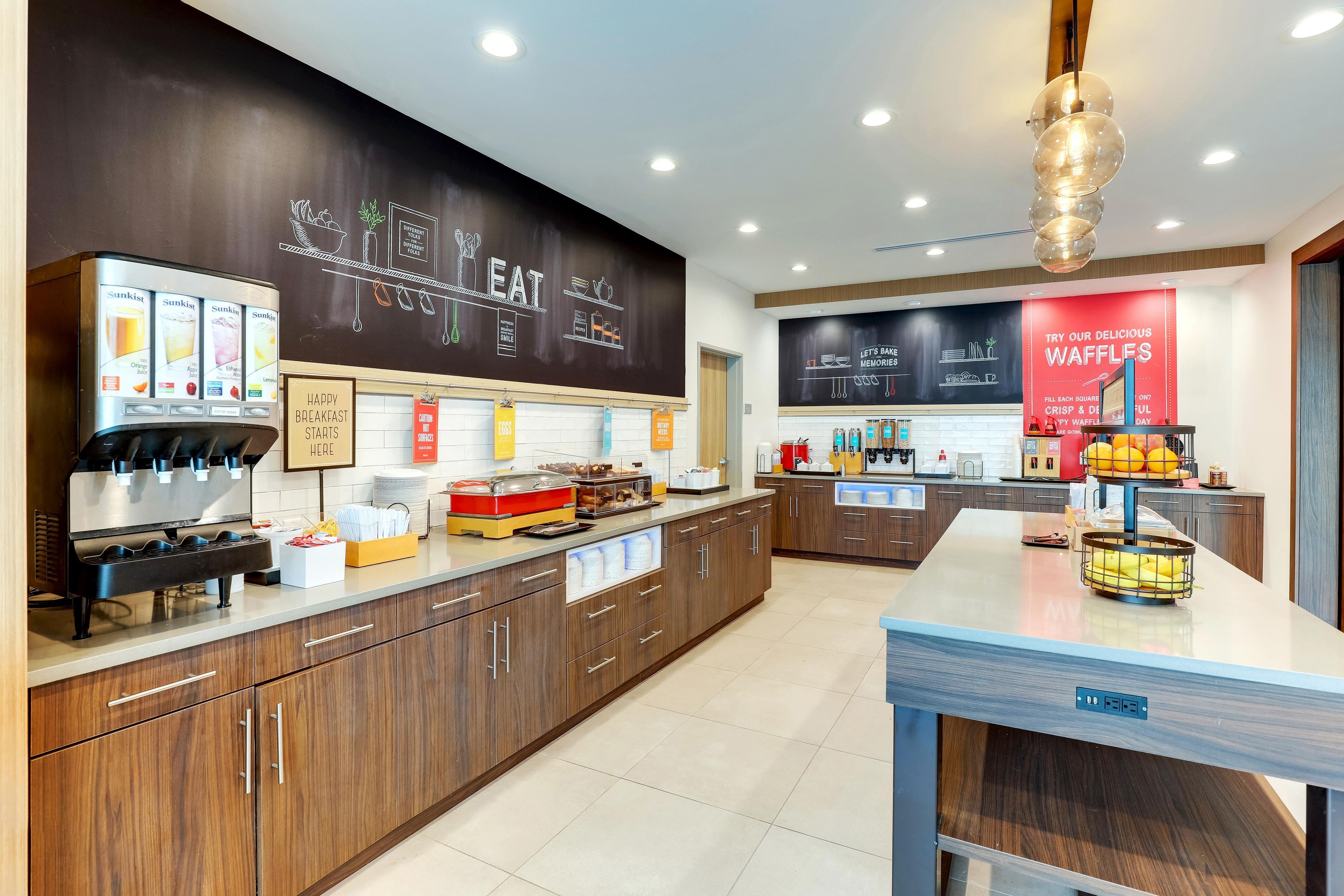 A modern cafe interior with a coffee machine, breakfast sign, and a waffle display.