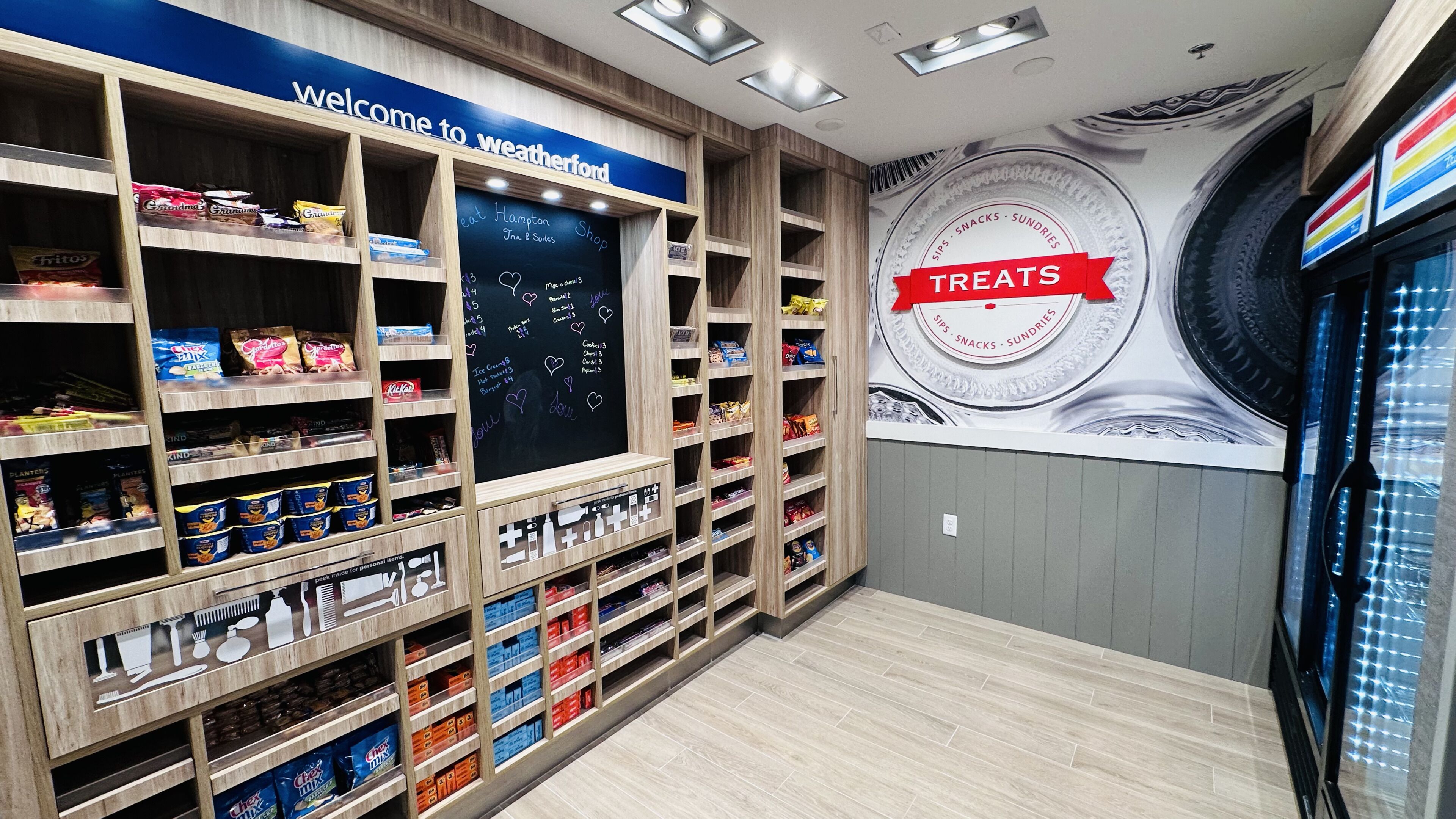 A snack display area with various packaged snacks and a chalkboard menu.