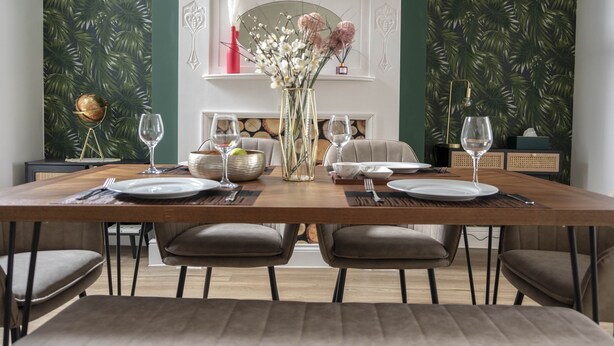 A dining room with a long table set for four, a fireplace, and tropical wallpaper. - The Callie by Sasco Apartments (Blackpool)