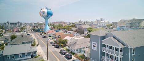 A residential street with houses, a water tower, and a building with a sign reading "CHIMAS".