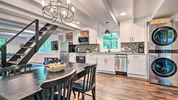 A modern kitchen with a central island, stainless steel appliances, and a staircase leading to another level. - Private Hot Tub & Fire Pit: Family Broadway Cabin (Broadway)