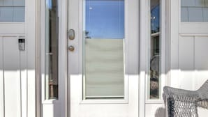 A white door with a window and a doorbell.