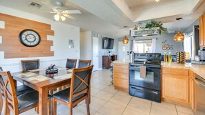 Una cocina moderna con una isla central, armarios de madera y un comedor con una mesa redonda y sillas.
