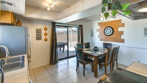 Una cocina moderna con comedor, un reloj en la pared y vistas al exterior.