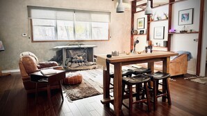 Ein gemütliches Wohnzimmer mit Kamin, Holzmöbeln und einem großen Fenster.