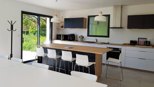 A modern kitchen with a central island, white bar stools, and pendant lighting. - TY BRAZ - Very large house 3 minutes walk from the beach (Baie Quiberon side) (Saint-Pierre-Quiberon)