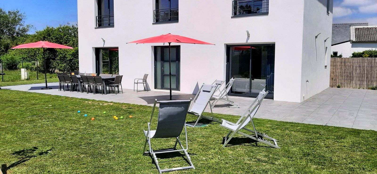 Un bâtiment moderne doté d’un patio aménagé avec des espaces de détente en plein air et des parasols.