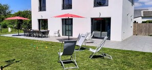 A modern building with a patio area featuring outdoor seating and umbrellas. - TY BRAZ – Very large house, a 3-minute walk from the beach (on the Baie de Quiberon side) (Saint-Pierre-Quiberon)