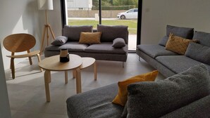 A modern living room with a grey sofa set, a wooden chair, a small round table, and a floor lamp. - TY BRAZ - Very large house 3 minutes walk from the beach (Baie Quiberon side) (Saint-Pierre-Quiberon)
