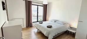 A bedroom with a bed, a desk, a chair, a radiator, and a window with curtains. - TY BRAZ – Very large house, a 3-minute walk from the beach (on the Baie de Quiberon side) (Saint-Pierre-Quiberon)