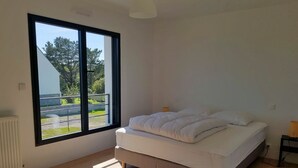 A bedroom with a large window, a bed, and a radiator. - TY BRAZ - Very large house 3 minutes walk from the beach (Baie Quiberon side) (Saint-Pierre-Quiberon)