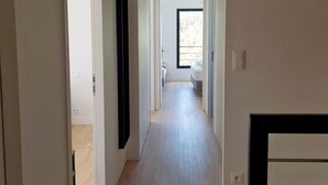 A modern, well-lit hallway with wooden flooring, leading to a bedroom with a large window and a hanging light fixture. - TY BRAZ - Very large house 3 minutes walk from the beach (Baie Quiberon side) (Saint-Pierre-Quiberon)