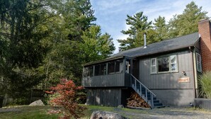 A two-story building with a wooden exterior, a visible staircase, and a chimney.