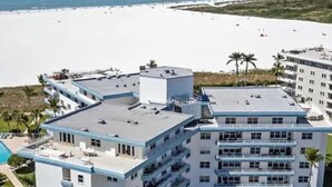 Ein mehrstöckiges Hotel mit Pool in Strandnähe.