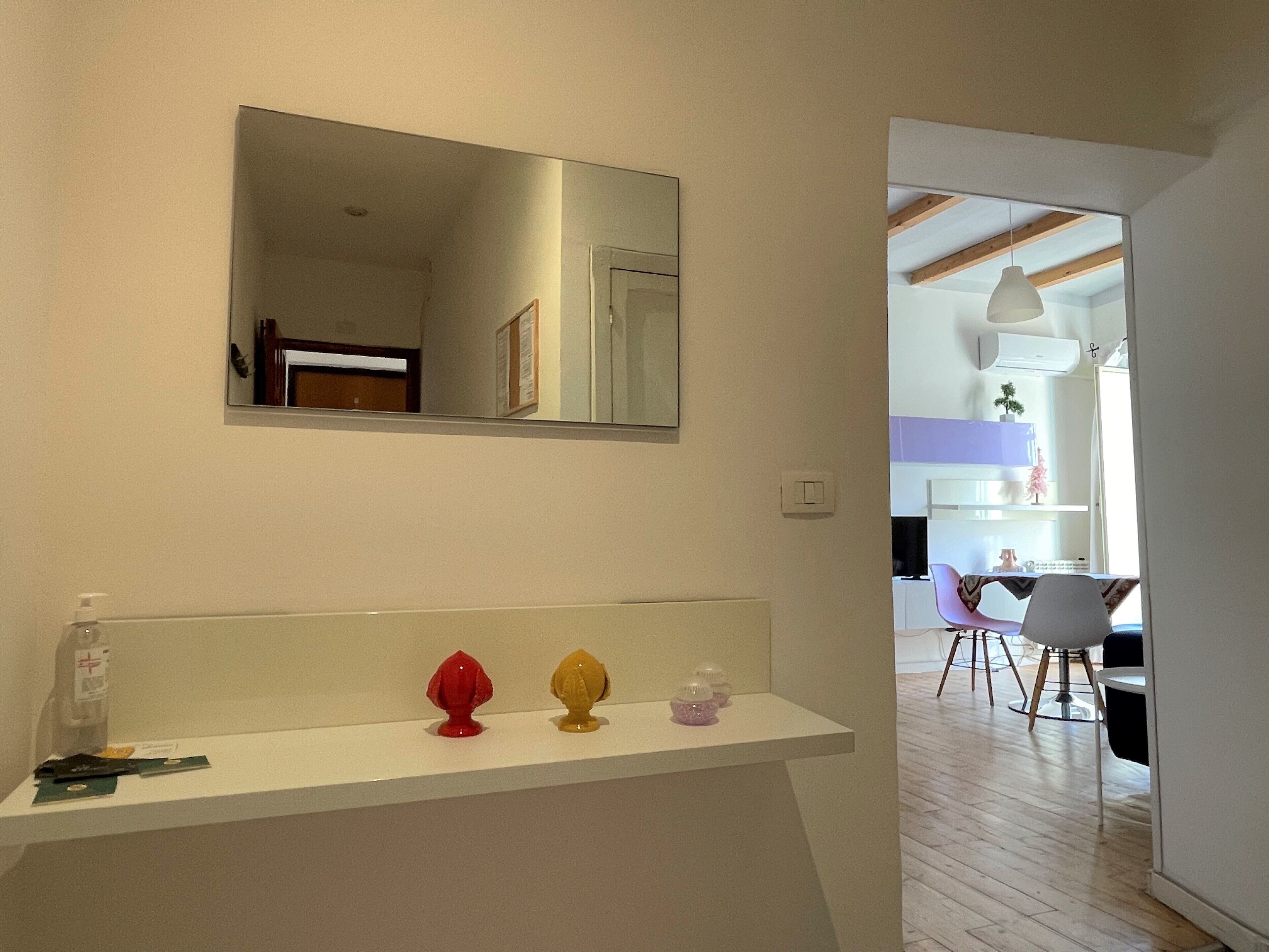 A bathroom with a white sink, a mirror above it, and a door leading to another room.