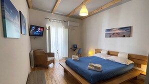 Une chambre à coucher avec un lit en bois, un bureau avec une chaise, une télévision et une fenêtre avec des rideaux.