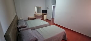 A hotel room with a bed, a desk with a computer, a TV, and a mirror. - Miga Hotel Airport (Isola di Capo Rizzuto)